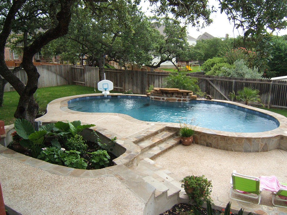 swimming pool with a small basketball goal and stone work