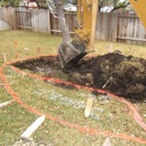 excavator digging up a large mound of dirt