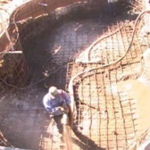 frame of a pool being placed by a construction worker