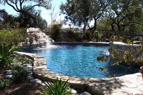 lushly wooded area with a pool and waterfall