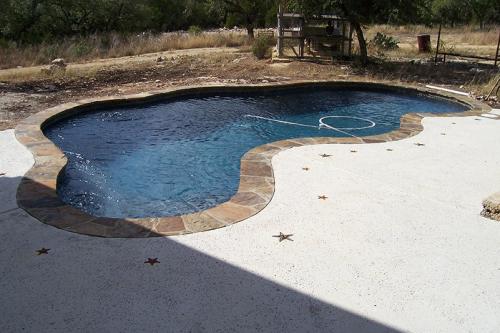 unfinished pool with debris on one side