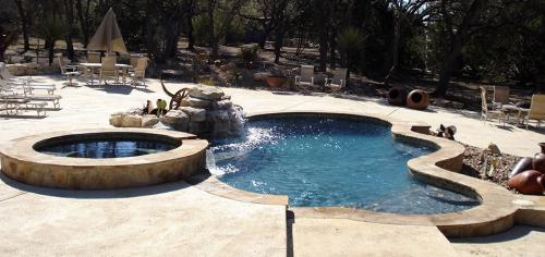 pool with a hot tub in a big wooded area